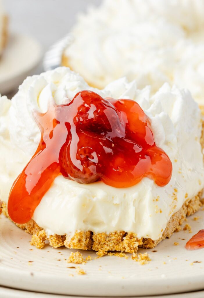 A slice of no bake cheesecake topped with strawberry pie filling.