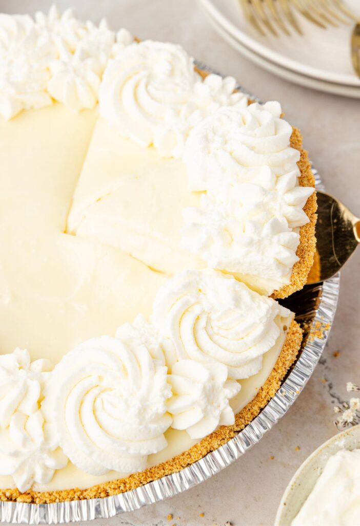 A serving spatula grabbing a slice of no bake cheesecake from the pie tin.