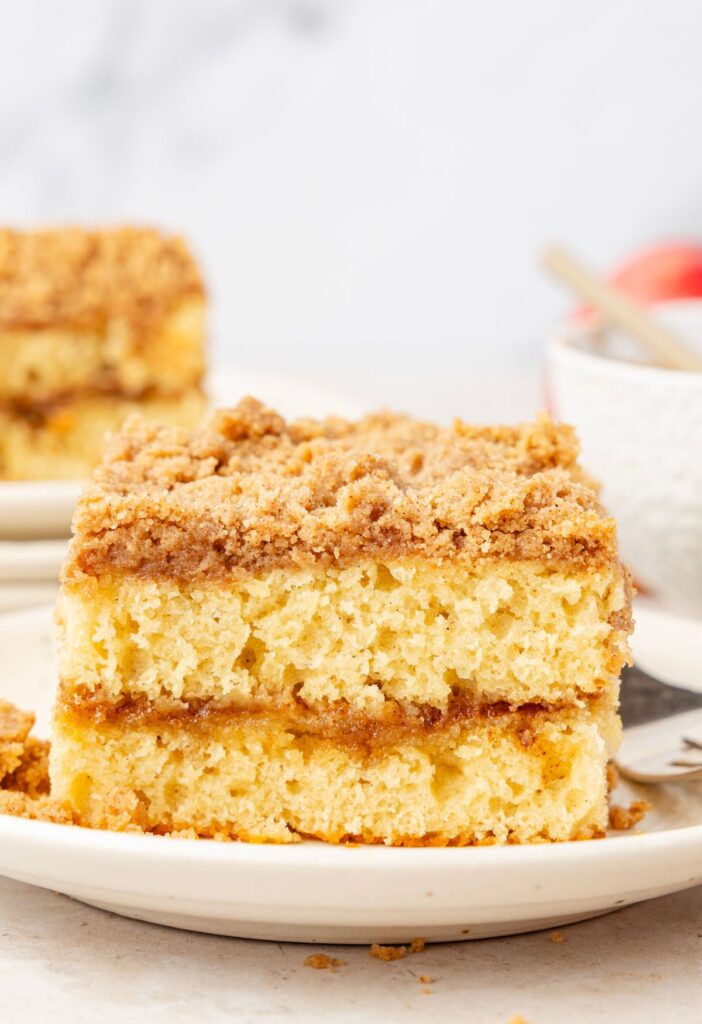 A slice of the coffee cake on a white plate with a fork