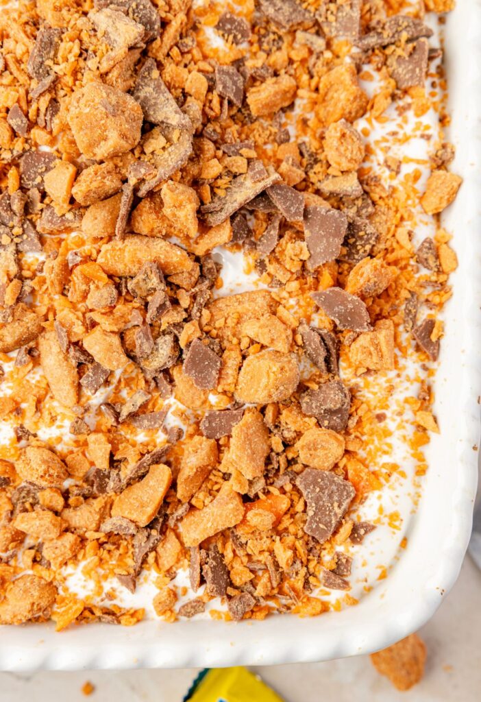 Top view of the top of the cake with butterfingers bits on top.
