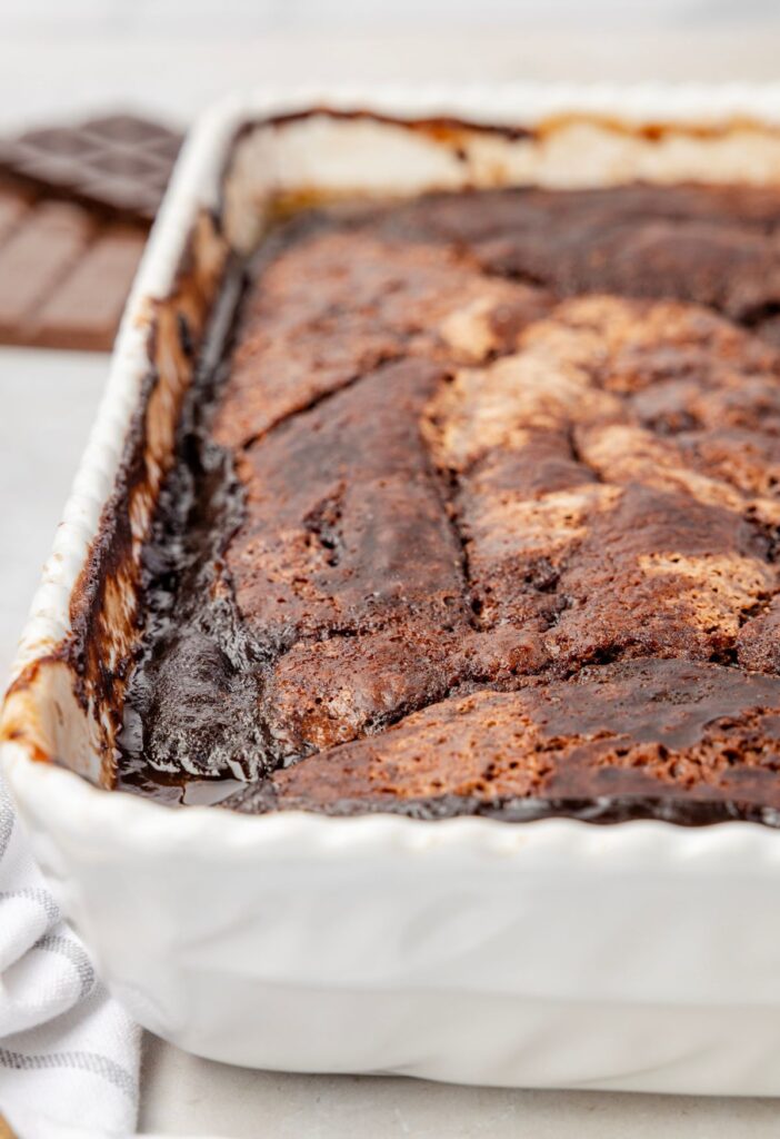 Side view of the white baking dish of the dessert cobbler in it.
