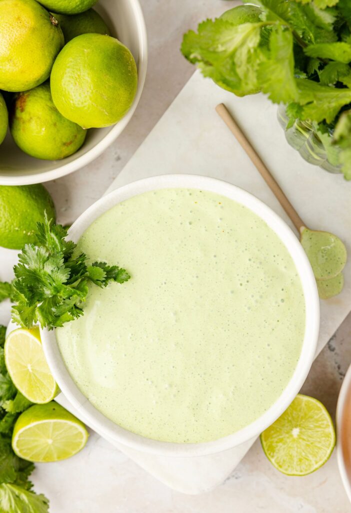 Overhead pic of the cilantro lime cream with limes and cilantro next to it.