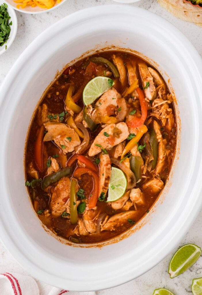 Inside of the slow cooker with the chicken fajita filling cooked and ready to serve.