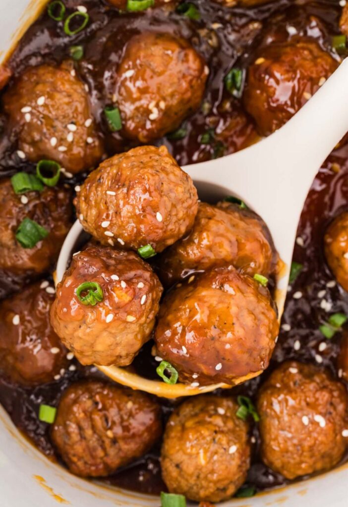 Close up of the cooked meatballs on a serving spoon