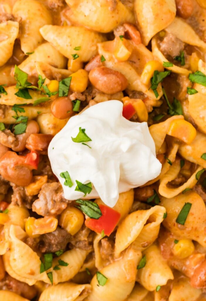 A close up of the cheesy taco pasta with sour cream on top.