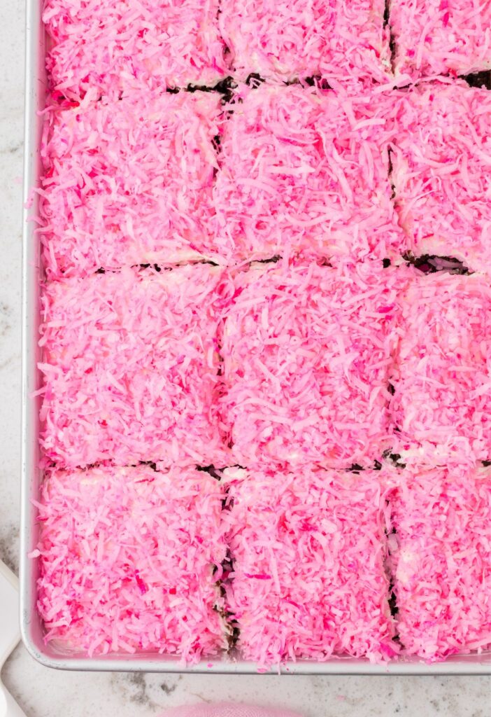 Top view of the poke cake with pink coconut topping on top.