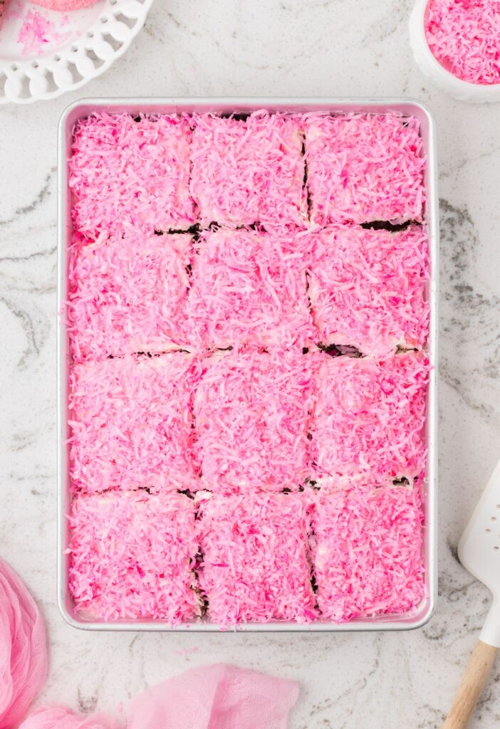 Top view of the pan of hostess snoballs poke cake with pink coconut around it.