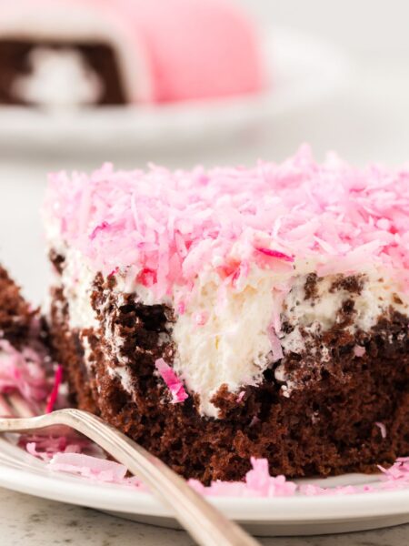 A slice of the poke cake that looks like a hostess snoballs snack cake