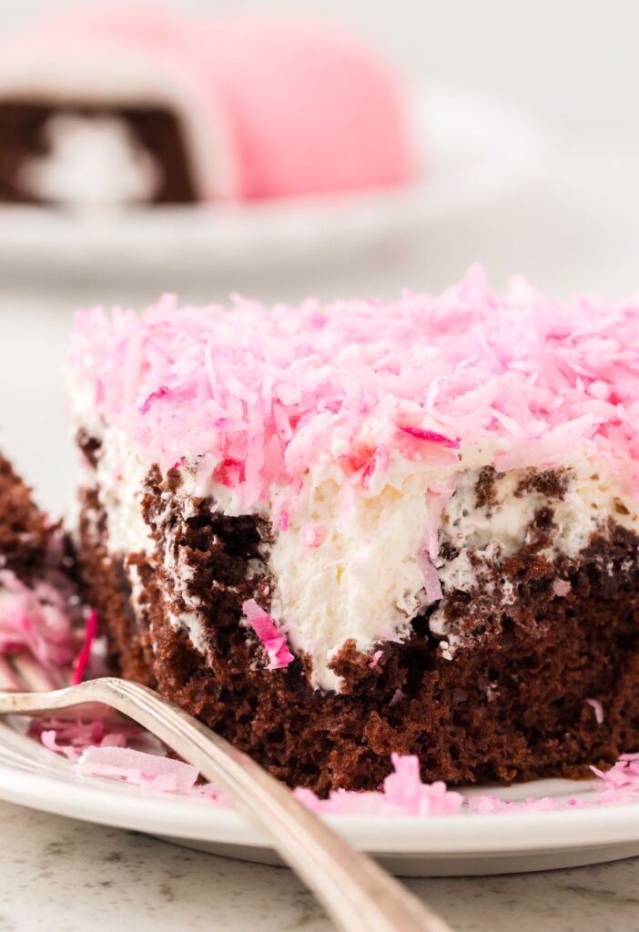 A slice of the poke cake that looks like a hostess snoballs snack cake
