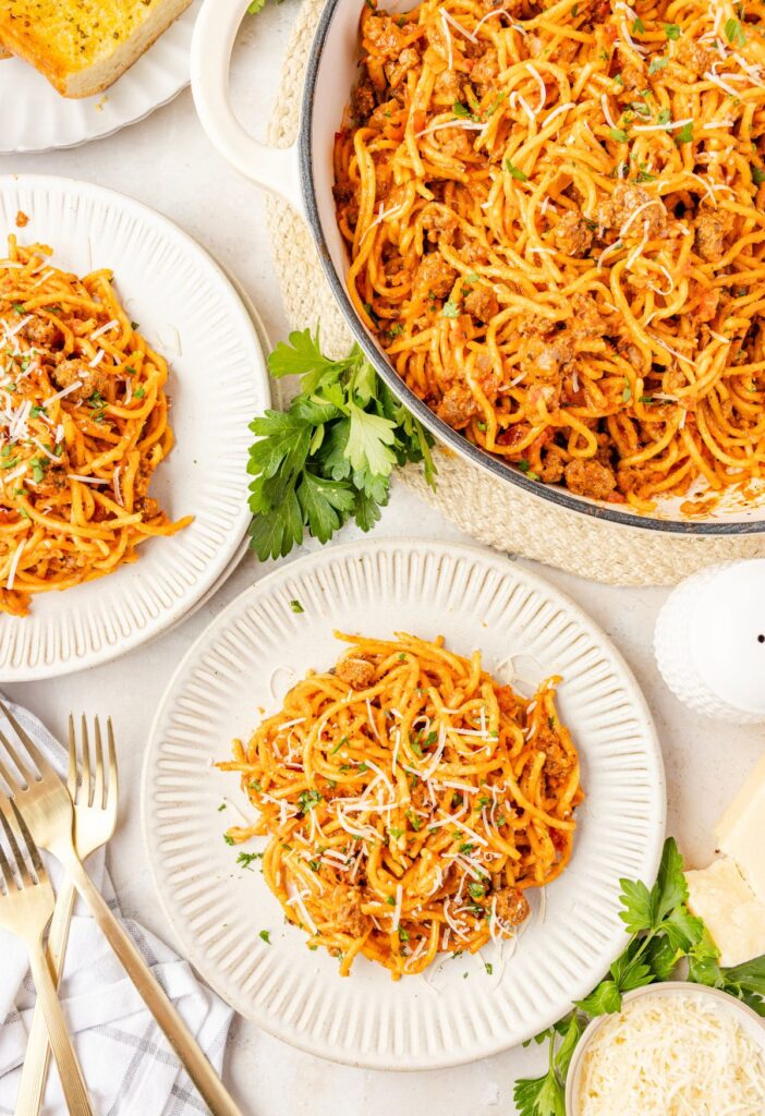 Top view of the pot of spaghetti and a plate with some on it for serving.