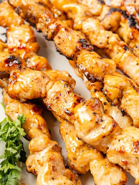 Cooked chicken skewers with a bang bang sauce glaze.