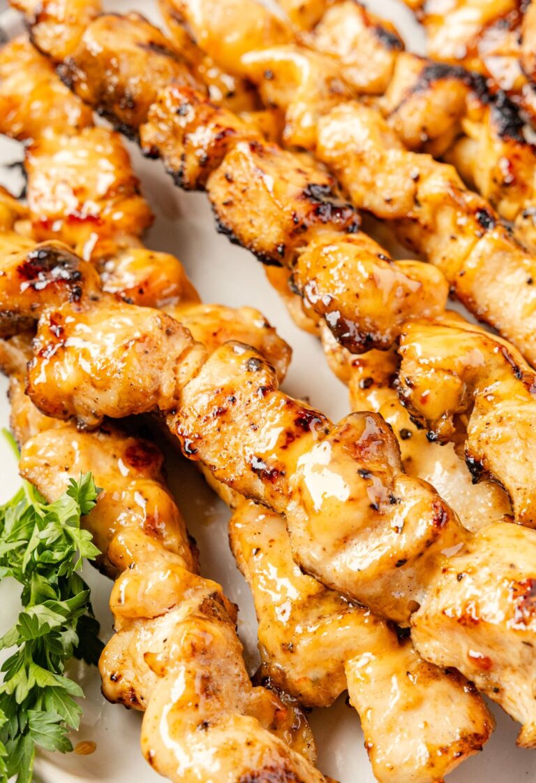 Cooked chicken skewers with a bang bang sauce glaze.