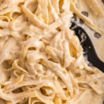 A skillet pan of the Alfredo sauce with pasta in it