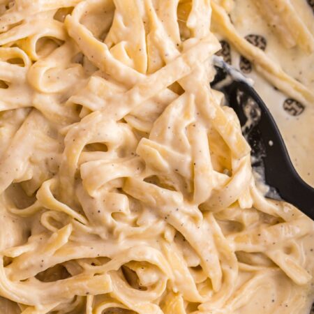 A skillet pan of the Alfredo sauce with pasta in it