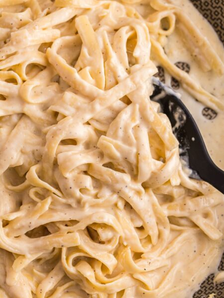 A skillet pan of the Alfredo sauce with pasta in it
