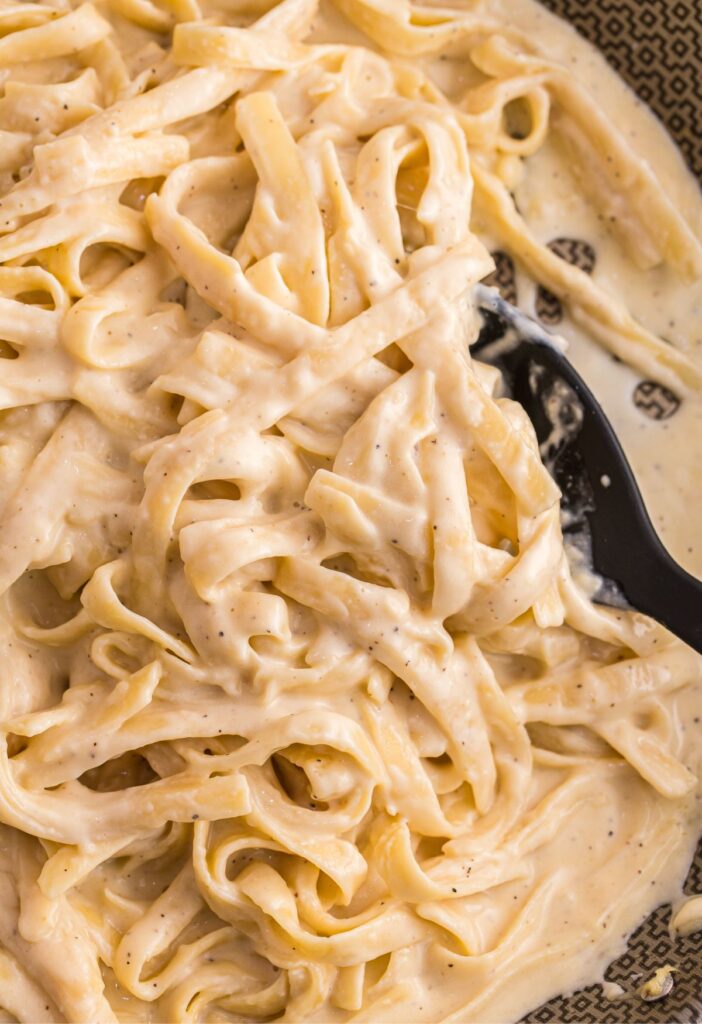 A skillet pan of the Alfredo sauce with pasta in it