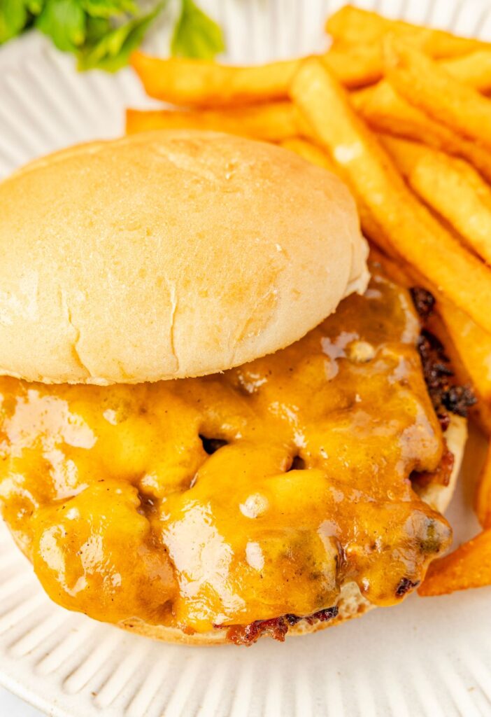 A cheeseburger with crack seasonings on a plate