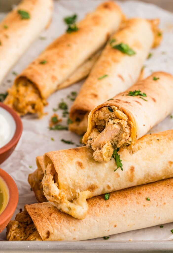 Chicken taquitos on a baking sheet