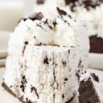 A slice of the Oreo cheesecake with a fork taking a bite out of it.