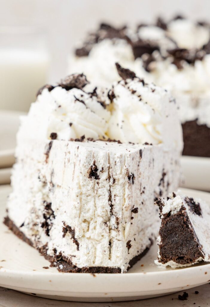 A slice of the Oreo cheesecake with a fork taking a bite out of it.