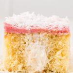 A slice of the cake that is showing the poked holes in the middle with cream filling.