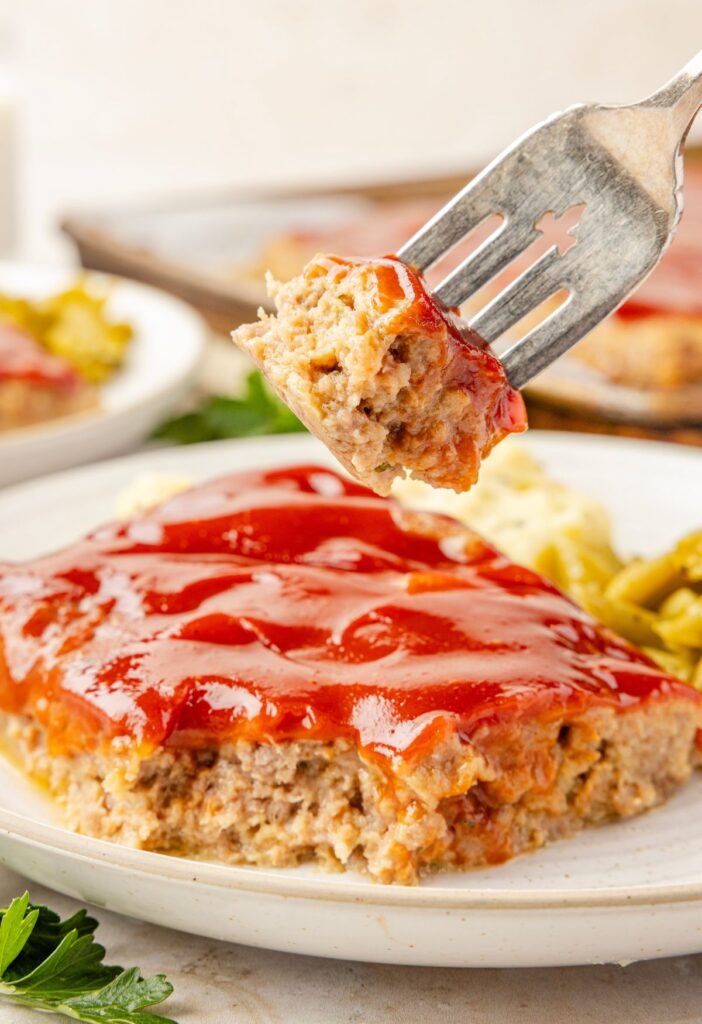 A fork with a bite of the meatloaf on it