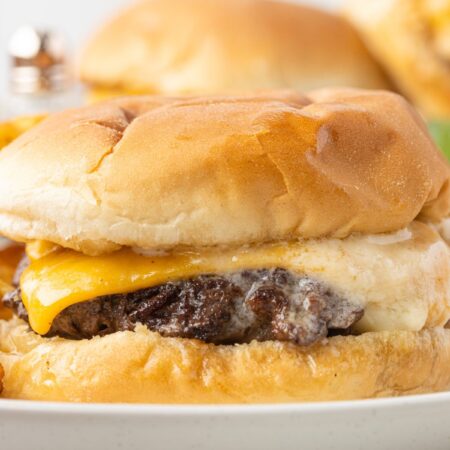 A butter burger on a plate with cheese