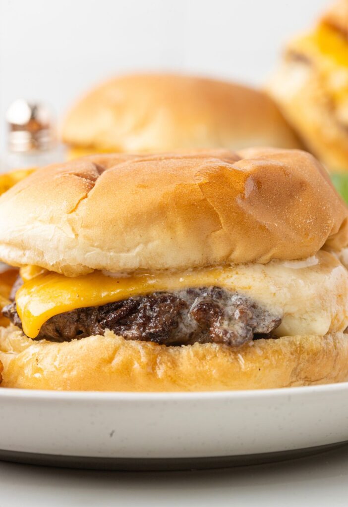 A butter burger on a plate with cheese