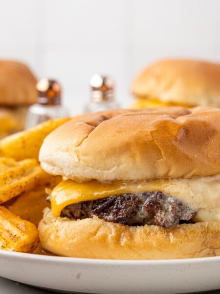 A butter burger with fries next to it on a plate