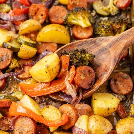 Sheet pan with roasted sausage and vegetables on it