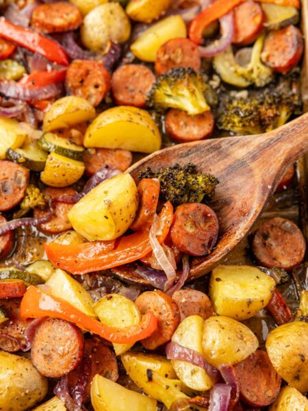 Sheet pan with roasted sausage and vegetables on it
