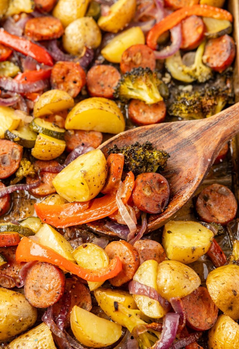 Sheet pan with roasted sausage and vegetables on it