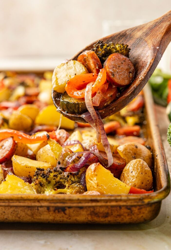 A wooden spoon with some on it above the sheet pan