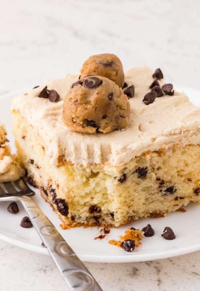 A slice of cake with a fork bite taken out of the corner
