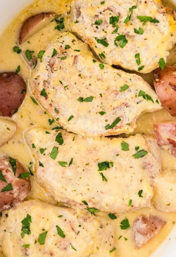 Inside the slow cooker with the cooked pork and potatoes.