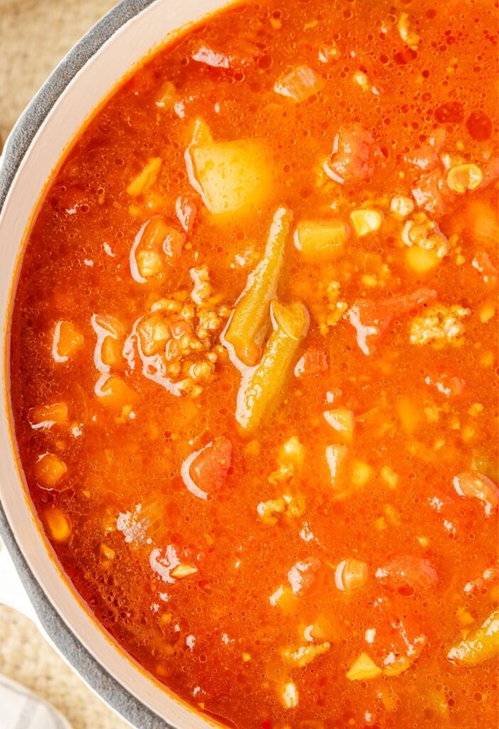 A soup pot of the hamburger soup inside of it ready to serve.
