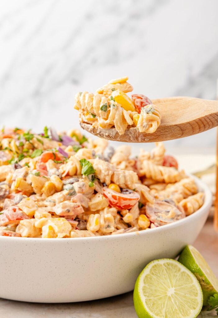 side pic of the pasta salad with a wooden spoon