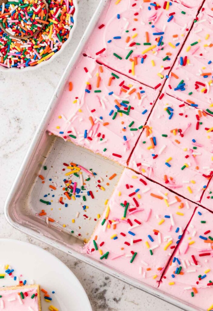 Top view of the cake inside the cake pan with sprinkles to the side.