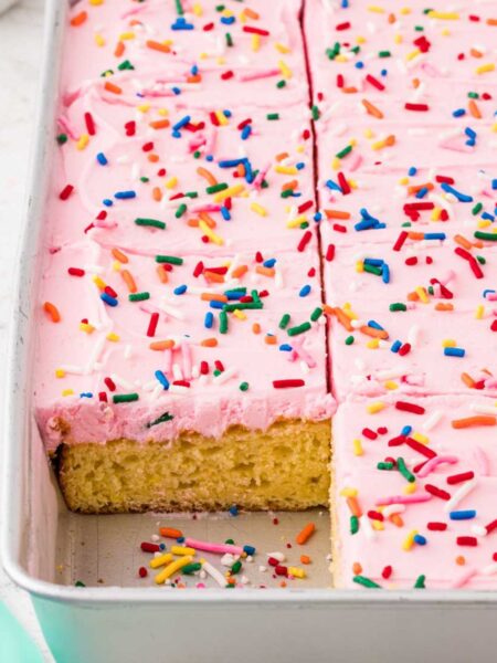 Side view of the cake pan with a corner piece cut out of the cake to see the vanilla cake center.