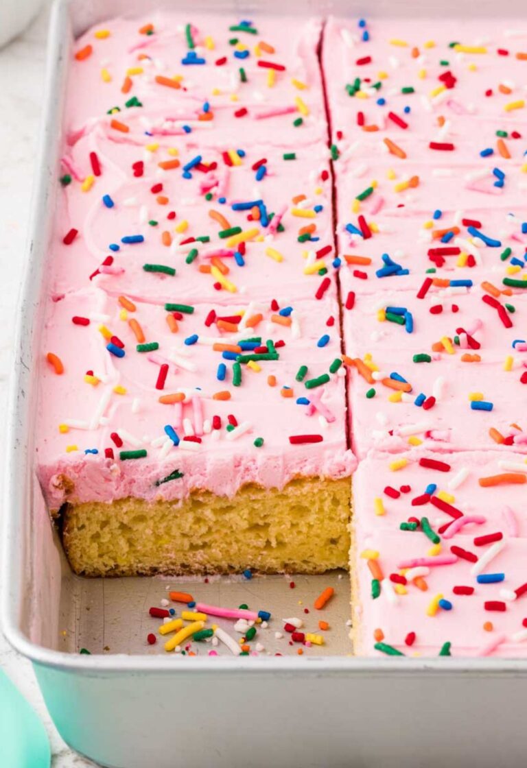 Side view of the cake pan with a corner piece cut out of the cake to see the vanilla cake center.