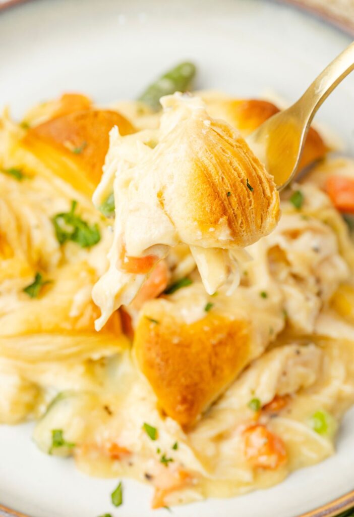 A fork with a bite of the biscuit casserole on it.