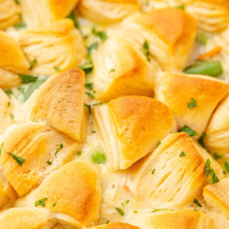 Close up image of the casserole with buttery biscuits on top of it that are golden brown.
