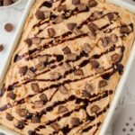 Top view of the baked cake ready to serve, with a peanut butter frosting and garnishes.