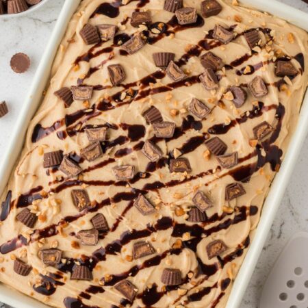 Top view of the baked cake ready to serve, with a peanut butter frosting and garnishes.