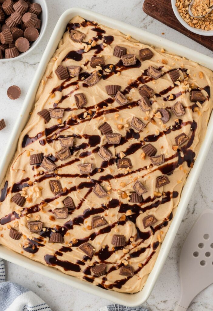 Top view of the baked cake ready to serve, with a peanut butter frosting and garnishes.