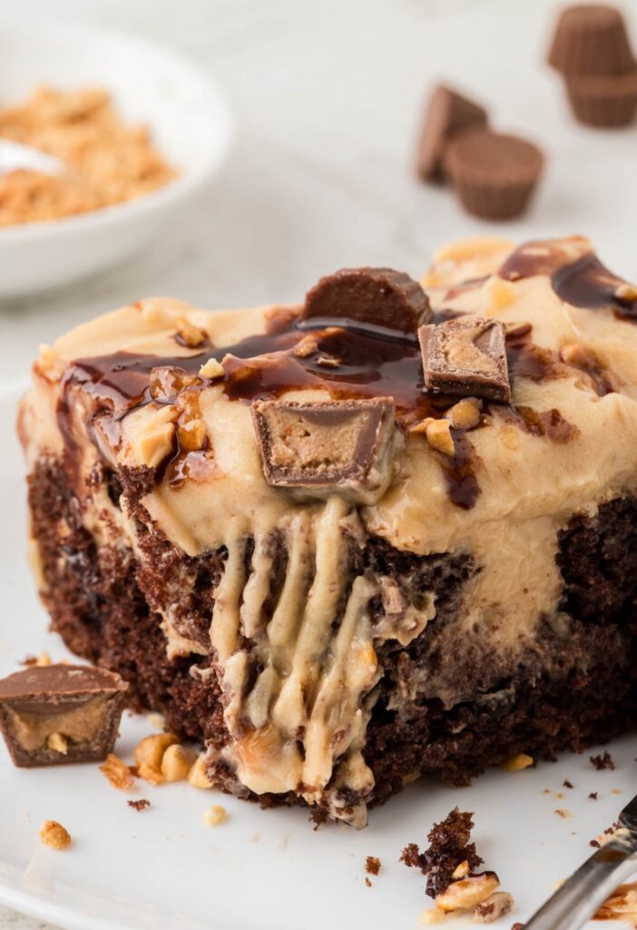 A slice of poke cake with a corner bite taken out with a fork to show the poke filling.