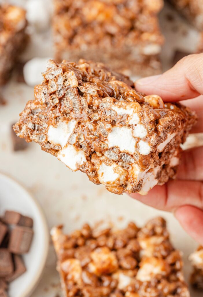 A hand holding a piece of rice Krispy treat