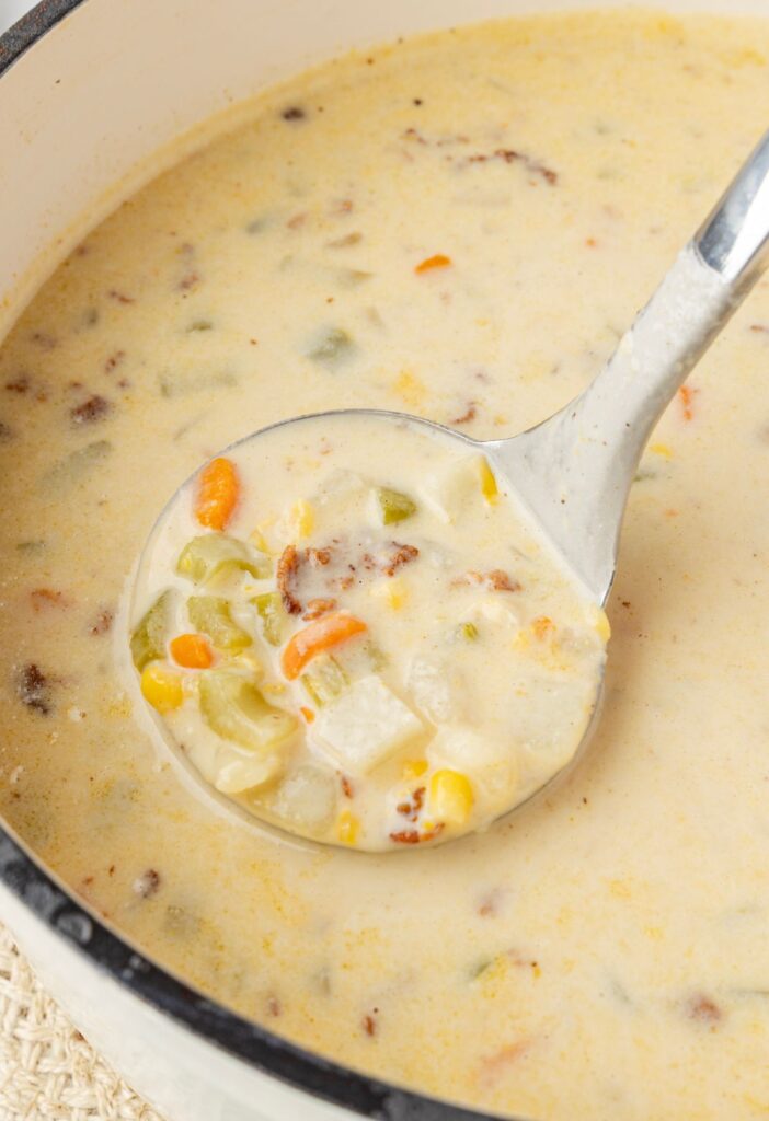 Close up image of the chowder inside a soup ladle scoop.