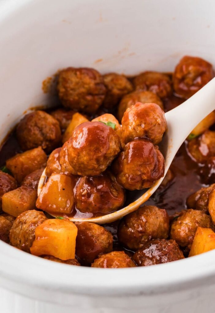 Serving spoon for the meatballs with pineapple chunks