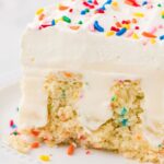 A slice of poke cake on a white plate